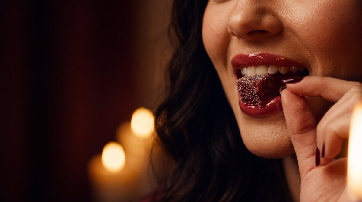 A woman biting into a Desire Cube by candlelight